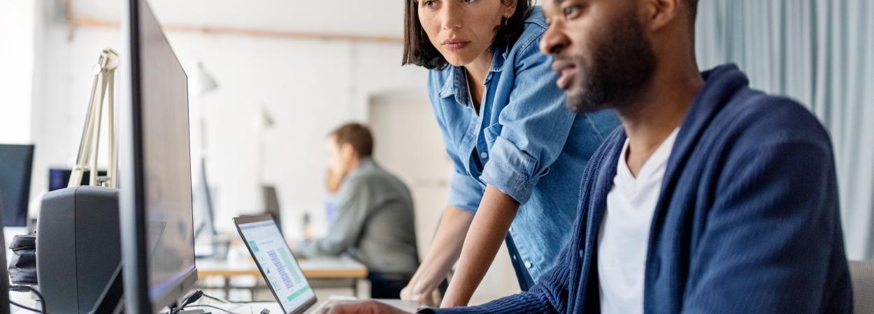 homem e mulher perante ecrã de computador