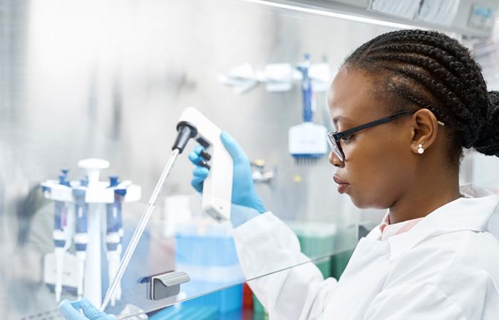 mulher de bata branca usando instrumentos de laboratório de biotecnologia