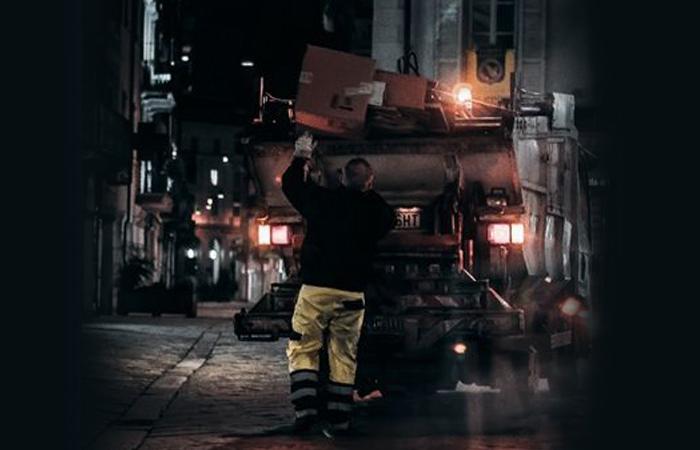 camião de recolha de lixo em rua escura